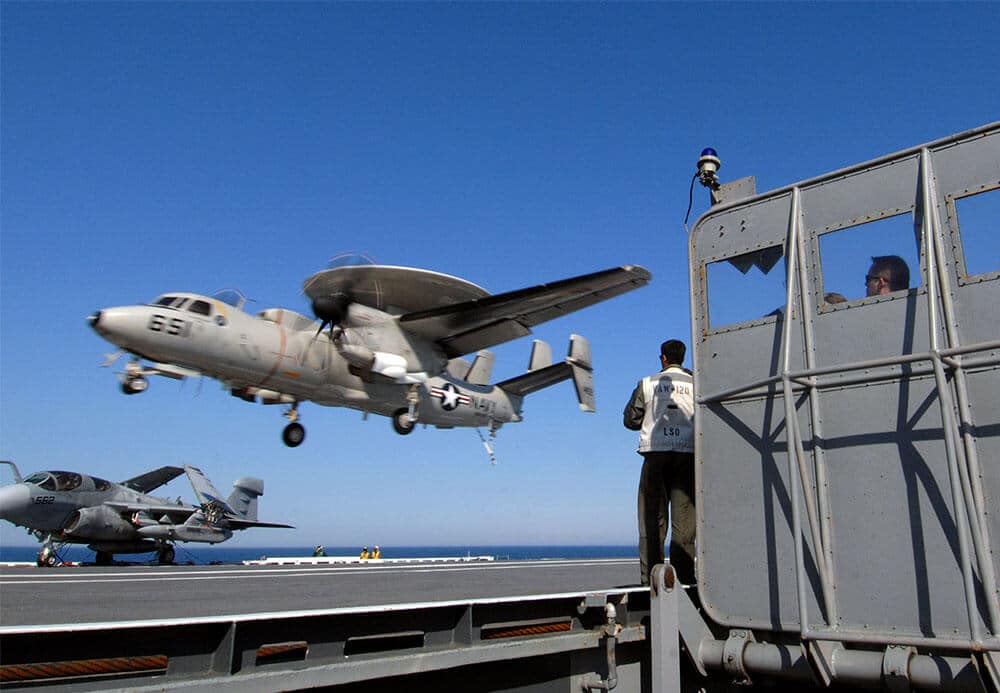 US Navy 070519 N 5345W 161 Landing signal officers LSO and lookouts watch from behind the LSO platform barricade as an E 2C Hawkeye