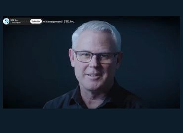 An older male smiling toward the camera, discussing cybersecurity management with SSE.