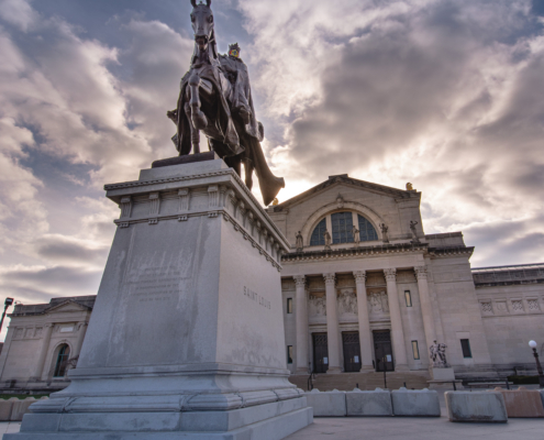 Saint Louis, MO—feb 7, 2021; statue of king Louis IX of France on a horse stands in front of the granite St Louis Art Museum with setting sun back lighting the architecture